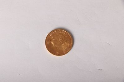 a small penny on a white surface with a white background
