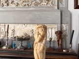 a statue on a table in front of a fireplace