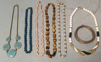 de nombreux colliers et bracelets différents disposés sur une table