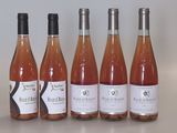 six bouteilles de vin sont alignées sur une table