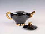 a black bowl with a gold handle and a black bowl with a gold handle