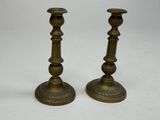 pair of antique brass candlesticks on a white background
