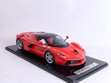 une maquette rouge d'une voiture de sport posée sur un socle noir