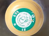 a yellow bowl with a green and white clock on it