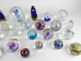 many different colored glass marbles on a white surface
