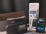 une télécommande, une radio et un téléphone portable posés sur une table