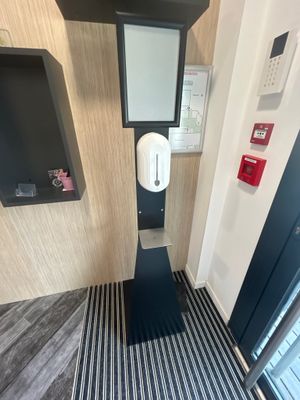 une salle de bains avec des toilettes et un miroir accroché au mur