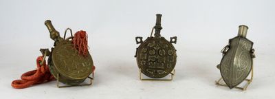 three small metal objects sitting on top of a white surface