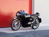 a black motorcycle parked in front of a red garage door