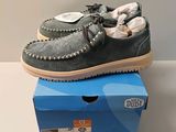 chaussures mocassins pour homme en daim gris, posées sur une boîte bleue