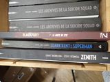 several books are stacked on top of each other on a shelf