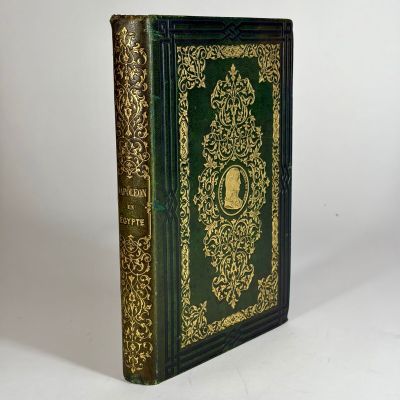 a green and gold book with gold trimming on the cover