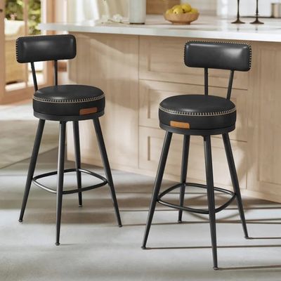 two black stools sitting in a kitchen next to a counter