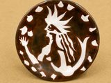 une assiette marron et blanche sur laquelle est représentée une femme