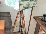 une lampe posée sur un trépied à côté d'une table