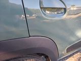 a close up of a car door handle with a reflection of a person in the background