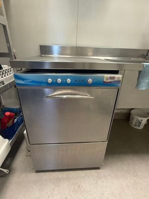 stainless steel dishwasher in a commercial kitchen next to a sink
