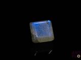 a close up of a square blue stone on a black surface