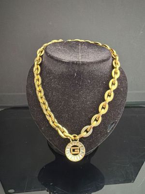 ensemble composé d'un collier et d'un bracelet plaqués or, exposé dans une vitrine