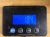 a digital clock that is on a wooden table