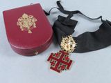a red box with a gold cross on it and a black ribbon