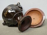 a brown vase sitting next to a brown vase on the floor