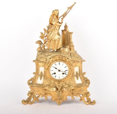 a gold clock with a statue on top of it