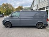 a grey van parked in a parking lot next to a building