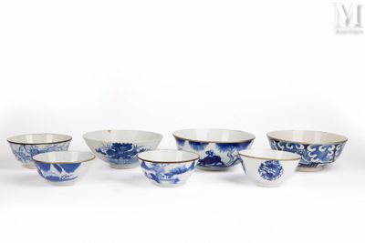 six bols en porcelaine bleue et blanche et un bol posé sur une surface blanche