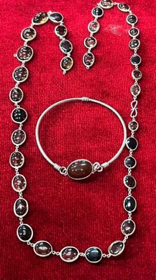 un gros plan d'un collier et d'un bracelet posés sur un tissu rouge