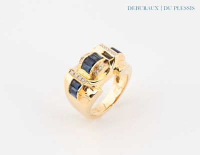gros plan d'une bague en or avec saphirs bleus et diamants