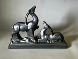 statue représentant un cheval et un chien, posée sur un socle, sur fond blanc