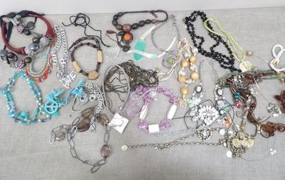 many different types of necklaces and bracelets on the table