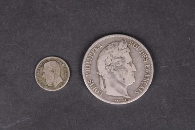 une vieille pièce d'argent et une pièce d'argent posée sur une surface noire