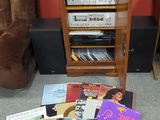 beaucoup de disques par terre, à côté d'une chaise