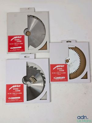 trois lames de scie circulaire dans une boîte posée sur une surface blanche