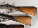 three old guns are displayed on a white surface
