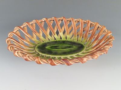 un saladier vert et marron posé sur une table blanche