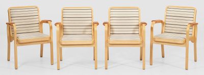quatre chaises en bois placées les unes à côté des autres sur un sol blanc