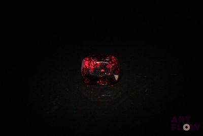 un gros plan sur un diamant rouge dans l'obscurité