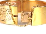 gold bracelet with a chain and a lock on a white surface