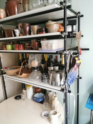 une étagère avec des casseroles et des poêles dans une cuisine