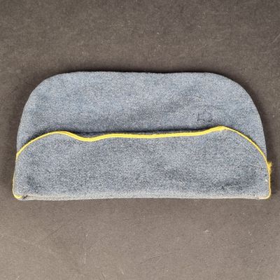 un gros plan d'un masque pour les yeux gris et jaune posé sur une surface marron