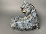 a sculpture of a bear sitting on a rock