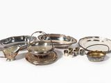 a lot of silver dishes and cups on the table