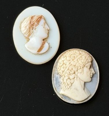 two cameos of a woman and a man on a black surface