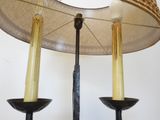 two candles that are on a table with a lamp