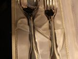 a silverware set in a box with a silver spoon and fork