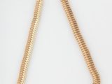 a close up of a gold necklace on a white surface
