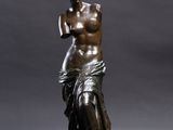 a bronze statue of a woman holding a glass